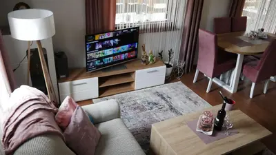 a living room with a couch and a flat screen tv at Kuća za Odmor Naša Priča in Šipovo