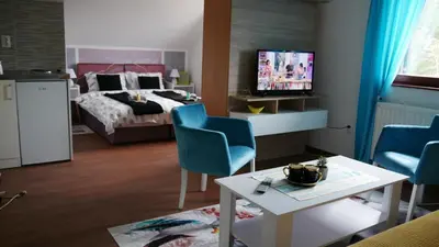 a bedroom with a bed and a table and chairs at Kuća za Odmor Naša Priča in Šipovo