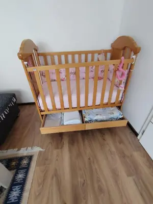 a crib in a room with a wooden floor at Stan na dan Prnjavor in Prnjavor