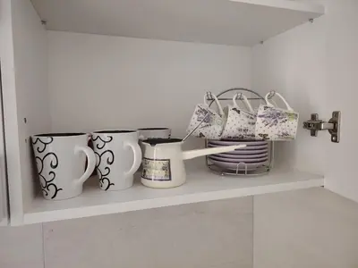 a shelf with three cups and plates on it at Stan na dan Prnjavor in Prnjavor