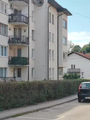 a car parked in front of a tall building at Stan na dan Prnjavor in Prnjavor