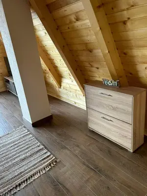 a attic room with a wooden ceiling and a dresser at Villa Forest Paradise in Visoko