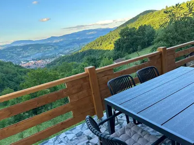 a table and chairs on a balcony with a view at Villa Forest Paradise in Visoko