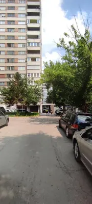 a parking lot with cars parked in front of a tall building at Apartman Slatina in Tuzla