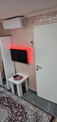 a room with a table and a tv and a door at Sobe Amar in Tuzla