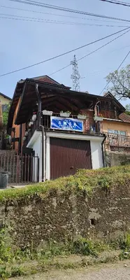a house with a blue sign in front of it at Sobe Amar in Tuzla
