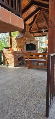 a patio with a stone fireplace and a picnic table at Sobe Amar in Tuzla