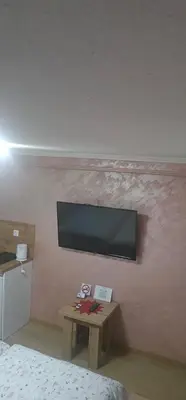 a bedroom with a tv on a wall with a table at Sobe Amar in Tuzla