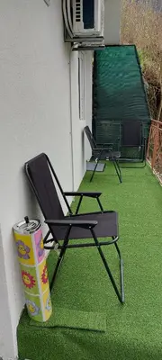 two lawn chairs and a trash can on a patio at Apartman Heli Meli 1 in Jajce