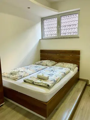 a bed in a bedroom with two windows at Hotel Irish in Bihać