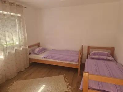 two twin beds in a room with a window at Sofija, Guests House in Ključ