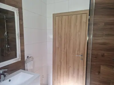 a bathroom with a wooden door and a sink at Sofija, Guests House in Ključ