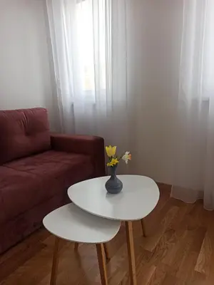 a living room with a white table and a couch at Apartman Ella in Banja Luka