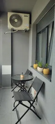 a table and chairs in a room with a fan at Apartman Ella in Banja Luka