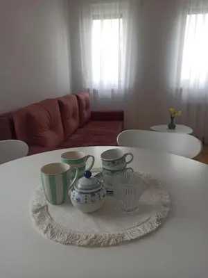 a table with four cups and a plate on it at Apartman Ella in Banja Luka