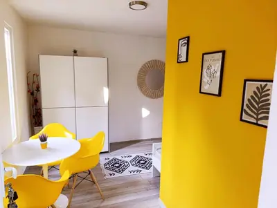 a yellow living room with a white table and yellow chairs at VA Apartments in Tešanj