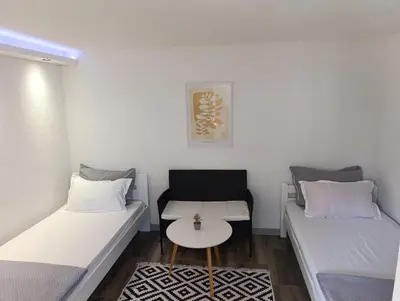 a small room with two beds and a table at VA Apartments in Tešanj