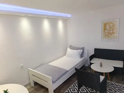 a small room with a bed and a table at VA Apartments in Tešanj