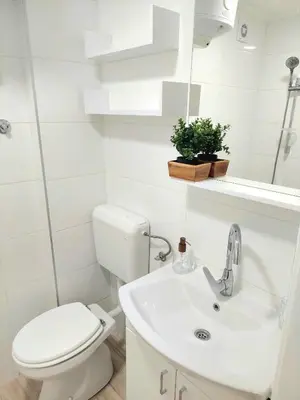 a white bathroom with a toilet and a sink at Plavi studio in Banja Luka