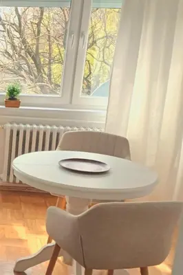 a white table and chairs in a room with a window at Plavi studio in Banja Luka