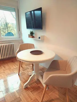 a table and two chairs in a room with a tv at Plavi studio in Banja Luka