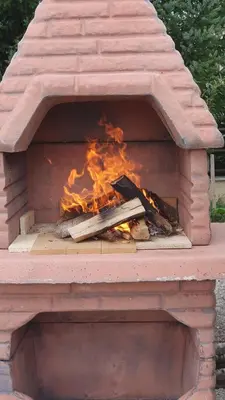 a brick oven with fire inside of it at Apartman Lena in Kupres