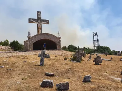 a man standing in front of a cross on a hill at Apartman Lena in Kupres