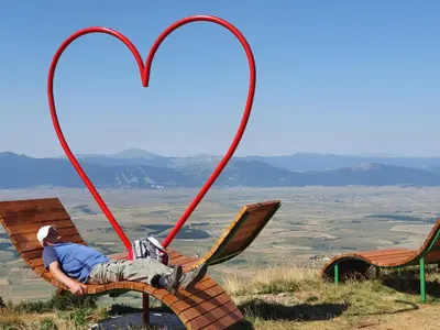 a man laying on a chair with two hearts on it at Apartman Lena in Kupres