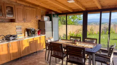 a kitchen with a table and chairs with a view at Vidikovac Cazin in Cazin