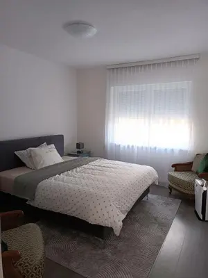 a bedroom with a large bed and a window at Apartman Centar A in Modriča