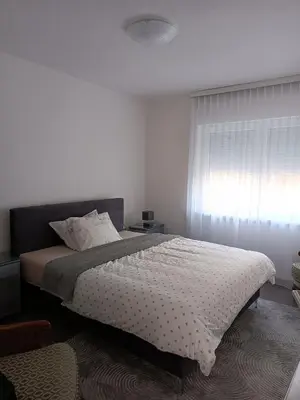 a bedroom with a large bed and a window at Apartman Centar A in Modriča