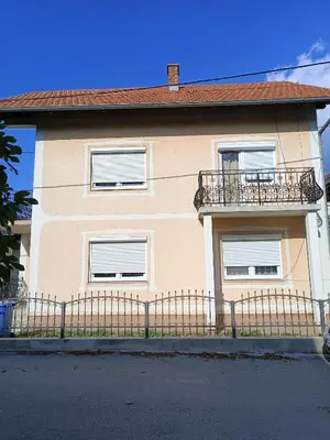 a house with a balcony and a fence at Apartman Centar A in Modriča