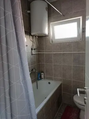 a bathroom with a tub and a toilet and a sink at Apartman Centar A in Modriča