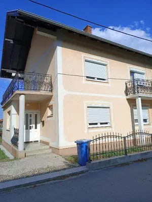 a house with two balconies and a blue trash can at Apartman Centar A in Modriča