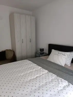 a bedroom with a large bed and a cabinet at Apartman Centar A in Modriča