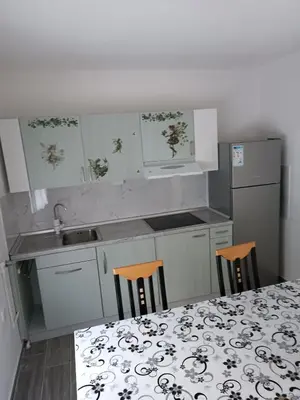 a kitchen with a table and two chairs and a sink at Apartman Centar A in Modriča