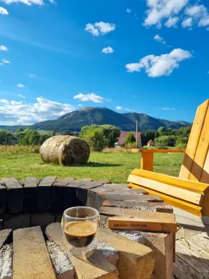 a glass of wine sitting on a table with a chair at Tiny Glamp House - DANGUBA by IGLENA in Kupres