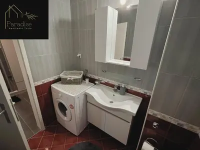 a bathroom with a sink and a washing machine at Apartment Paradise in Tuzla