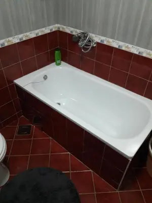 a white tub in a bathroom with red tiles at Apartment Paradise in Tuzla