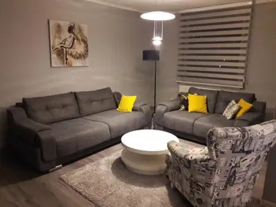 a living room with two couches and yellow pillows at Apartment Paradise in Tuzla