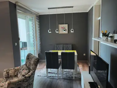 a living room with a dining room table and chairs at Apartment Paradise in Tuzla