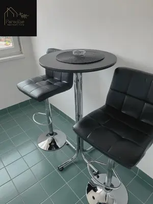 a table and a black chair in a room at Apartment Paradise in Tuzla