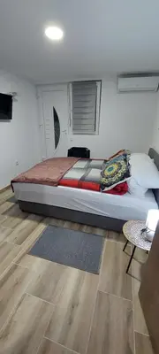 a bedroom with a large bed and a table at Apartman Heli Meli 2 in Jajce