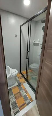 a bathroom with a toilet and a glass door at Apartman Heli Meli 2 in Jajce
