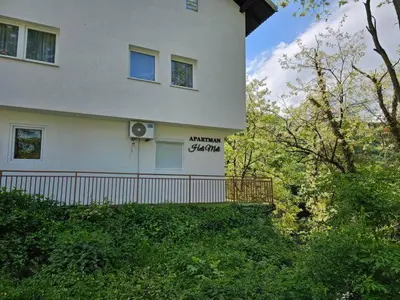 a white house with a sign on the side of it at Apartman Heli Meli 2 in Jajce