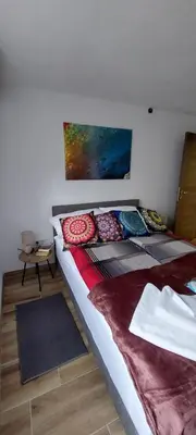 a bedroom with a large bed with pillows on it at Apartman Heli Meli 2 in Jajce