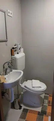 a bathroom with a white toilet and a sink at Apartman Heli Meli 2 in Jajce