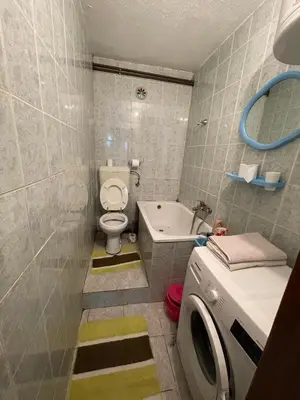 a bathroom with a toilet and a washing machine at Stan na dan Tomic in Rebrovac