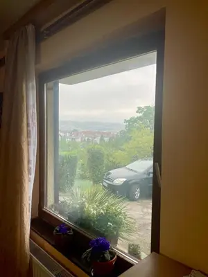 a window with a view of a car in a parking lot at Stan na dan Tomic in Rebrovac