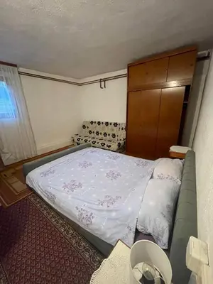a small bedroom with a bed and a cabinet at Stan na dan Tomic in Rebrovac